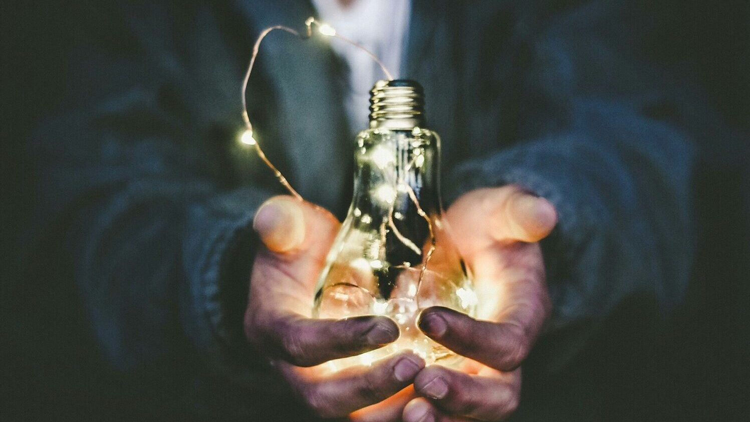 man holding incandescent bulb